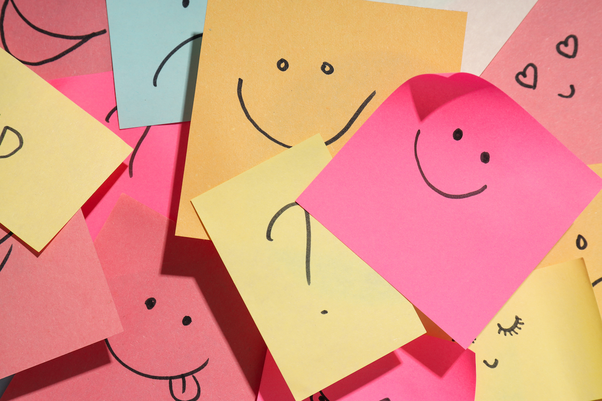 Un munt de pòstits posats damunt de l'altre amb cares somrients dibuixades, atès que la dinàmica pretén que l’alumnat escrigui un element positiu de la classe