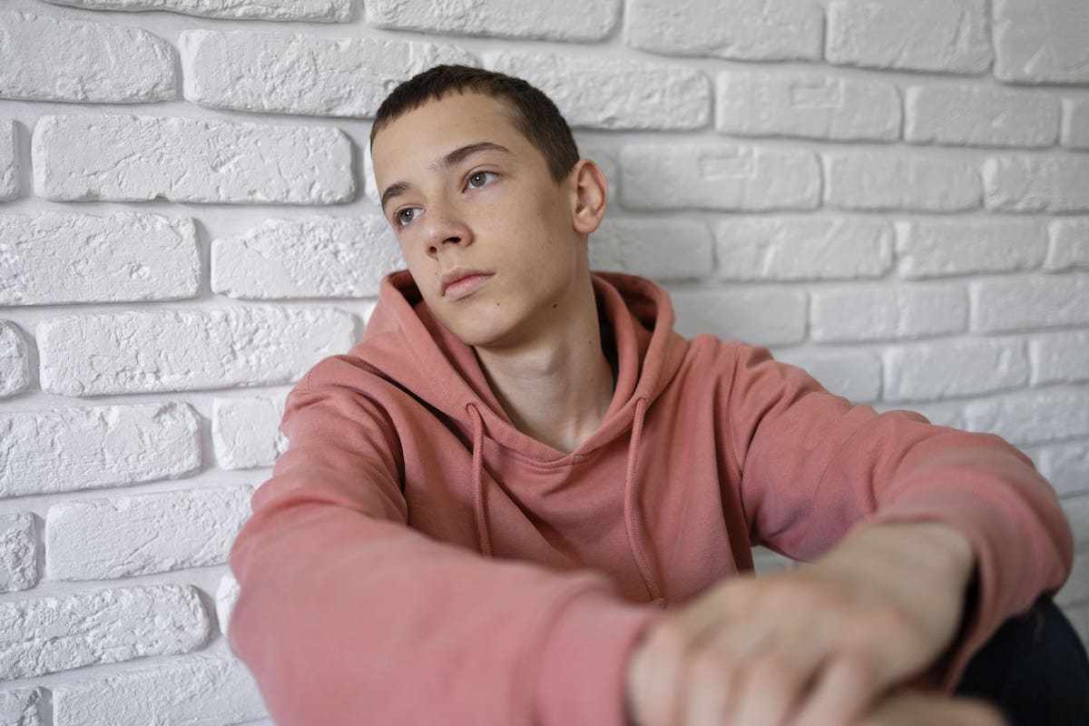 Guia pràctica per a educadors, amb la imatge amb la que treballa SJD d'un jove amb la mirada perduda sentat a terra per al·ludir a la importància que els professors, educadors, i la resta de professionals dels centres educatius coneguin l'elevada prevalença de l'autolesió en els joves, així com els mètodes més habituals i els motius pels quals les persones recorren a l'autolesió.