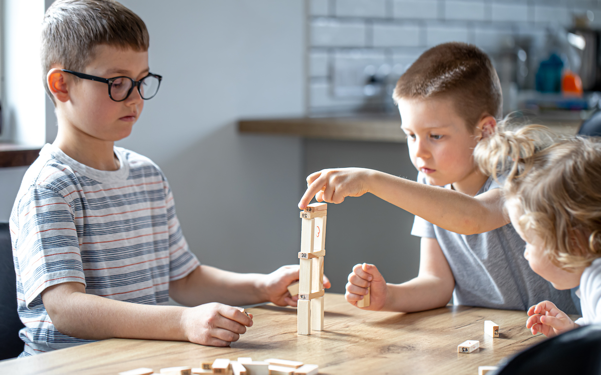 Dos infants estan construint una torre plegats com un repte que suggereix la dinàmica d'aprenentatge per mantenir la motivació entre l'alumnat