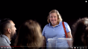 Imatge del video on es veu la mesa electoral i una persona amb discapacitat que vol votar.