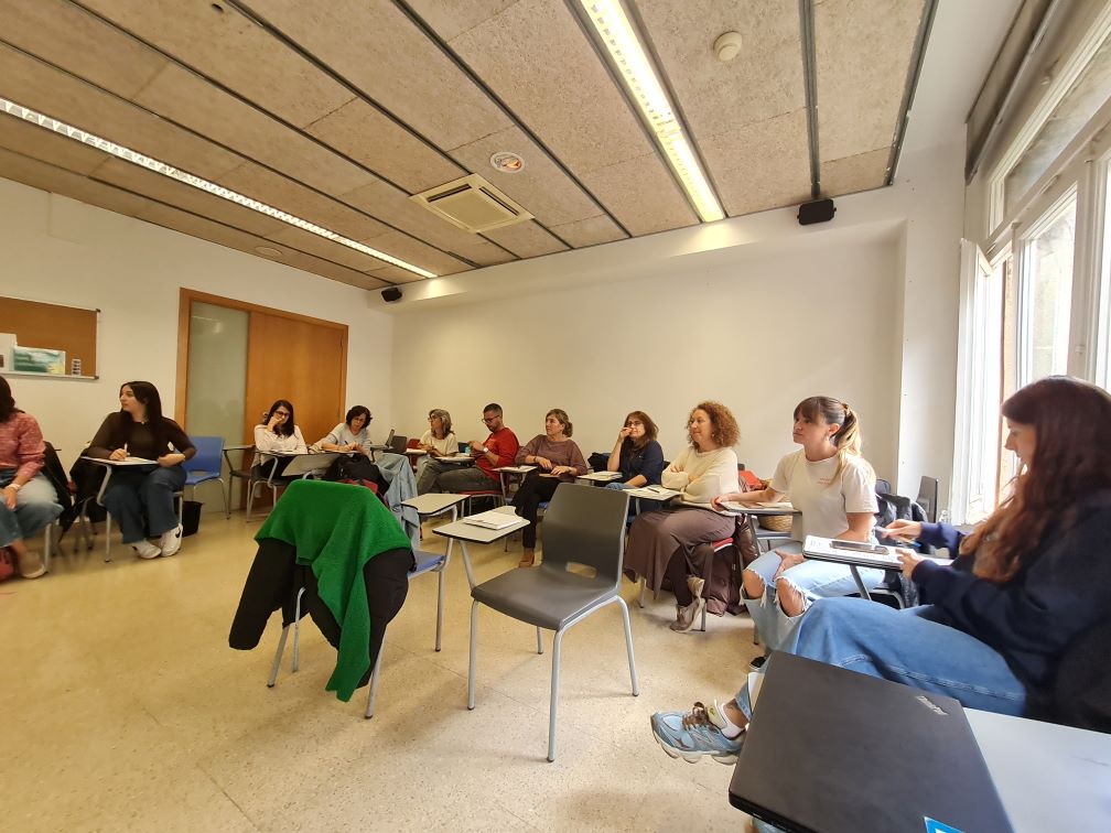 Persones reunides en una aula treballant