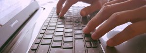 teclat d'ordinador amb una persona escrivint
